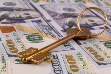 100 Amerikan dolarının arka planında altın anahtar var.