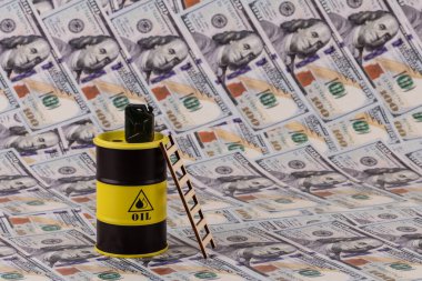 100 dolarlık banknotlara karşı bir benzin bidonu ve bir varil petrol..