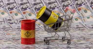 Bir alışveriş arabasındaki demir varil petrol, 100 dolarlık banknotlarla karşılaştırıldığında...