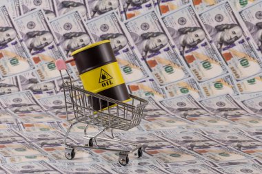 Bir alışveriş arabasındaki demir varil petrol, 100 dolarlık banknotlarla karşılaştırıldığında...