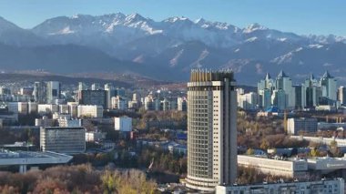 Almaty, Kazakistan 'ın merkez kısmının insansız hava aracı görüntüsü, Kazakistan Oteli ile birlikte Trans-Ili Alatau Dağları' nın tepesinde bir sonbahar sabahı.
