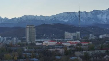 Almaty, Kazakistan 'ın merkez kısmının insansız hava aracı görüntüsü, Kazakistan Oteli ile birlikte Trans-Ili Alatau Dağları' nın tepesinde bir sonbahar sabahı.