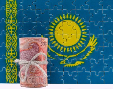 Kazakistan Cumhuriyeti 'nin yapboz bayrağına karşı 5000 tenge banknot yığını..