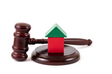 Simetrik ahşap bir ev ve beyaz bir arka planda yargıç tokmağı.