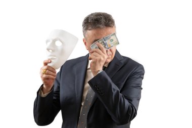 Elinde 100 dolarlık banknot ve beyaz maske tutan orta yaşlı bir iş adamı.