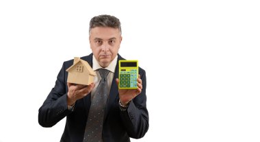 Sembolik ahşap bir ev ve hesap makinesi tutan orta yaşlı bir adamın yer aldığı bir emlak acentesinin kavramsal hikayesi..