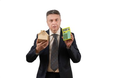 Sembolik ahşap bir ev ve hesap makinesi tutan orta yaşlı bir adamın yer aldığı bir emlak acentesinin kavramsal hikayesi..