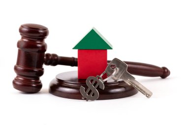 Sembolik ahşap ev, Amerikan doları sembollü anahtarlık ve beyaz arka planda yargıç tokmağı.