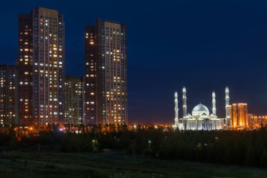 Kazakistan 'ın başkenti Astana' daki Hazret Sultan Camii ve konut binaları, gece geç saatlerde.