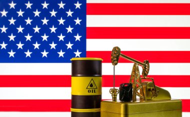 Amerikan bayrağının arka planında altın bir petrol pompası