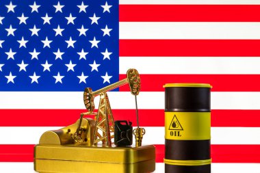 Amerikan bayrağının arka planında altın bir petrol pompası