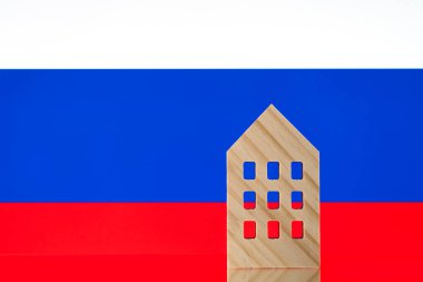 Rus bayrağının arka planına karşı sembolik ahşap bir ev..