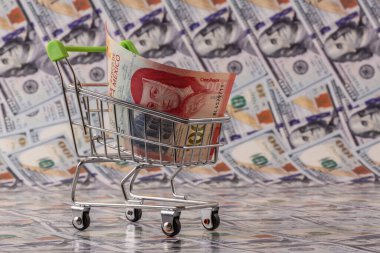 100 Meksika pezosu süpermarket alışveriş arabasının arka planında 100 dolar banknot var.