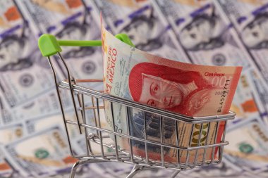 100 Meksika pezosu süpermarket alışveriş arabasının arka planında 100 dolar banknot var.