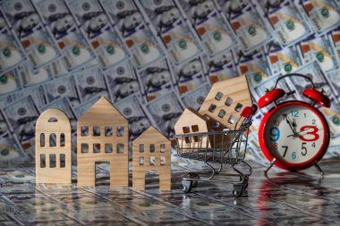 100 dolarlık banknotların arka planına karşı sembolik ahşap evler