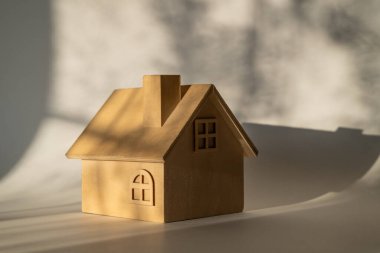 Sembolik ahşap ev, gölgeli bir duvara karşı.