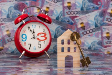 100 adet Kazakistan banknotuna karşılık altın anahtarı olan sembolik ahşap bir ev..