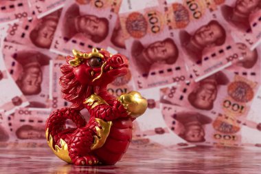 Sembolik bir Çin ejderhası figürü. Bilgelik, güç, uzun yaşam ve güç sembolü. 100 Çin yuan banknotunun arka planına karşı iyi şans ve refah getiriyor..