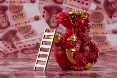 Sembolik bir Çin ejderhası figürü. Bilgelik, güç, uzun yaşam ve güç sembolü. 100 Çin yuan banknotunun arka planına karşı iyi şans ve refah getiriyor..
