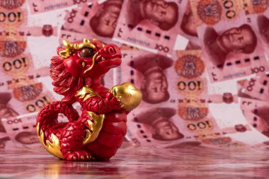 Sembolik bir Çin ejderhası figürü. Bilgelik, güç, uzun yaşam ve güç sembolü. 100 Çin yuan banknotunun arka planına karşı iyi şans ve refah getiriyor..