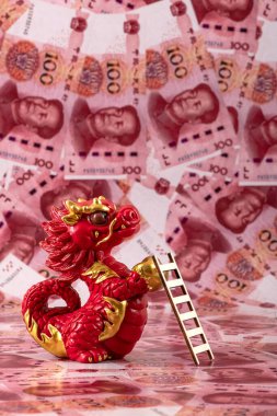 Sembolik bir Çin ejderhası figürü. Bilgelik, güç, uzun yaşam ve güç sembolü. 100 Çin yuan banknotunun arka planına karşı iyi şans ve refah getiriyor..
