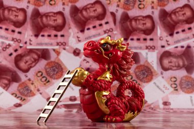 Sembolik bir Çin ejderhası figürü. Bilgelik, güç, uzun yaşam ve güç sembolü. 100 Çin yuan banknotunun arka planına karşı iyi şans ve refah getiriyor..
