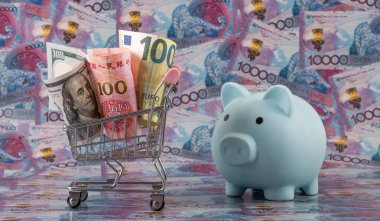 100 Amerikan Doları, 100 Çin Yuanı ve 100 Euro 'luk banknotlar bir alışveriş arabasında 10.000 Kazakistan tenge faturasına karşı.