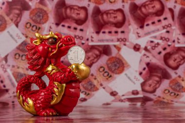 Sembolik bir Çin ejderhası figürü. Bilgelik, güç, uzun yaşam ve güç sembolü. 100 Çin yuan banknotunun arka planına karşı iyi şans ve refah getiriyor..