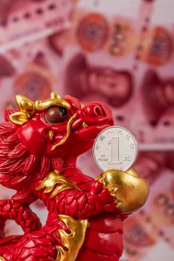 Sembolik bir Çin ejderhası figürü. Bilgelik, güç, uzun yaşam ve güç sembolü. 100 Çin yuan banknotunun arka planına karşı iyi şans ve refah getiriyor..