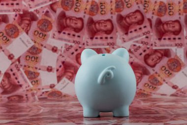 100 Çin Yuan 'ının arka planına karşı bir kumbara.