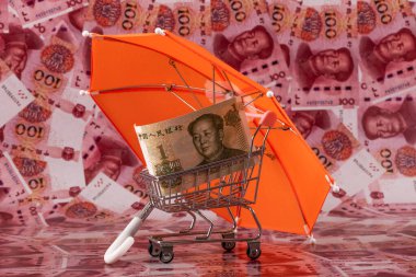 Bir Çin Yuan faturası süpermarket alışveriş arabasında şemsiyenin altında 100 Çin Yuan 'ının arka planında