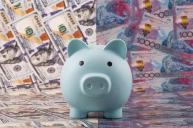 100 dolar ve 10.000 Kazakistan banknotlarına karşılık bir kumbara..