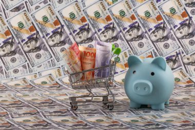 Latin Amerika ülkelerinden banknotlar - Meksika, Venezuela ve Arjantin - minyatür bir alışveriş arabasında 100 dolarlık banknotlara karşı