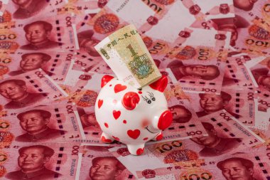 100 Çin yuan banknotunun arka planında insan kalbi sembolü olan komik bir kumbara..