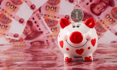 100 Çin yuan banknotunun arka planında insan kalbi sembolü olan komik bir kumbara..