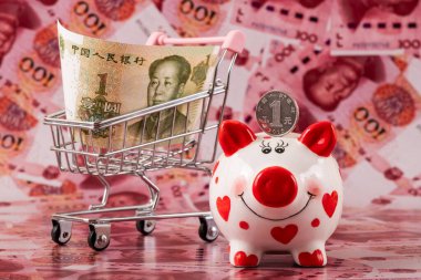 100 Çin yuan banknotunun arka planında insan kalbi sembolü olan komik bir kumbara..