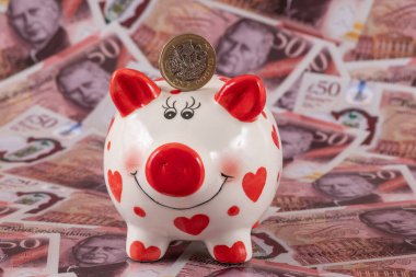 İnsan kalbi sembolü ve 1 İngiliz poundu olan komik bir kumbara.