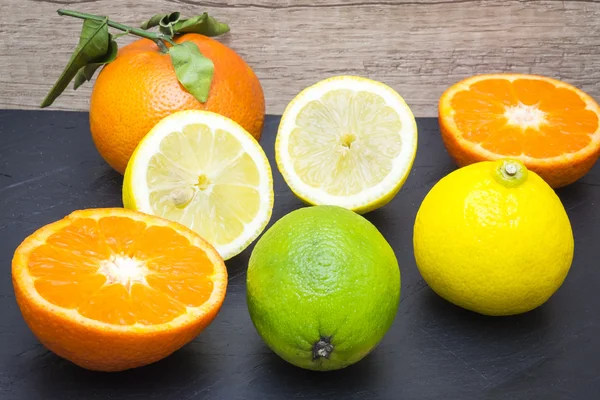 Několik zralých citrusových plodů na zásobník břidlice — Stock fotografie