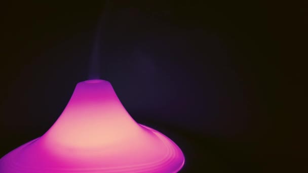 Пар из увлажнителя воздуха с розовым светом на темном фоне — стоковое видео