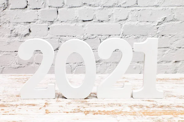 Number 2021 on a board with a white brick background. Happy New Year concept