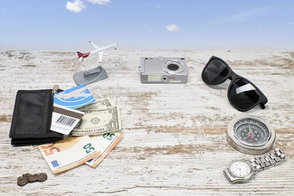 Airplane with camera, compass, sunglasses and money as a vacation and adventure travel concept