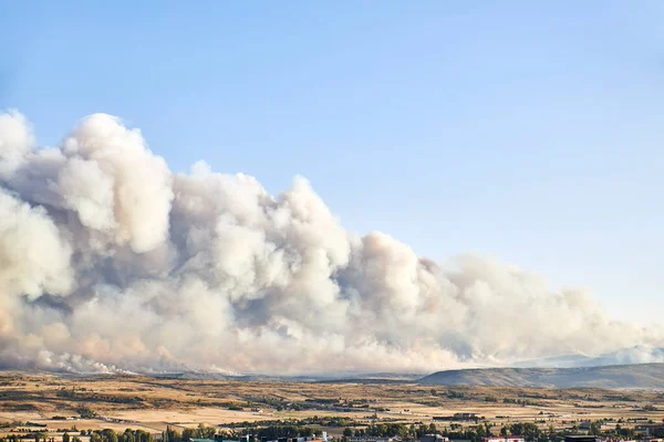 Dark and dense smoke clouds from a fire in Spain. Close-up of a large smoke cloud in the sky from a forest fire, air pollution.