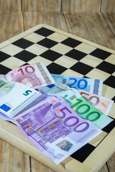 Ett schackbräde, siffror och pengar — Stockfoto
