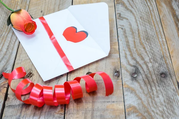 Corazón en un sobre blanco y una rosa para el Día de San Valentín — Foto de Stock