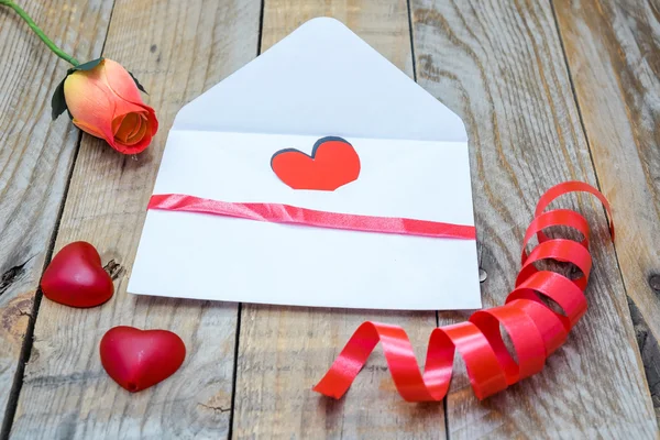 Beyaz bir zarf ve bir Gül Sevgililer günü için kalp — Stok fotoğraf