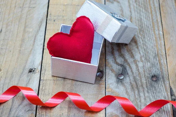 Pudełko z kokardą i czerwone serce wewnątrz — Zdjęcie stockowe