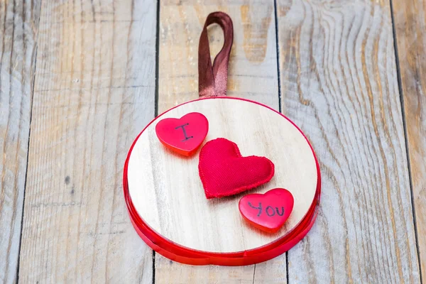 Colgante de madera con tres corazones rojos en el centro y la palabra "Te amo" " — Foto de Stock