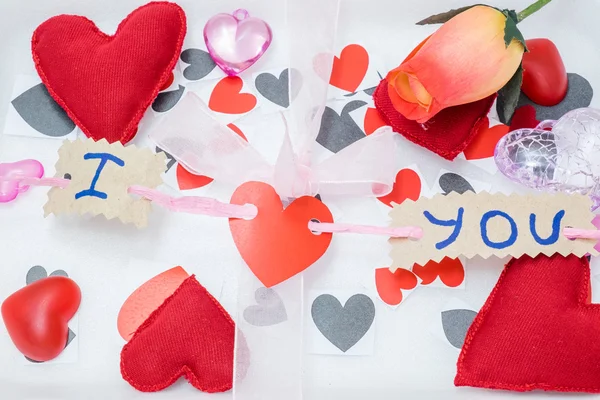 Många hjärtan i olika färger och former och ett rosa band på en vit bakgrund — Stockfoto
