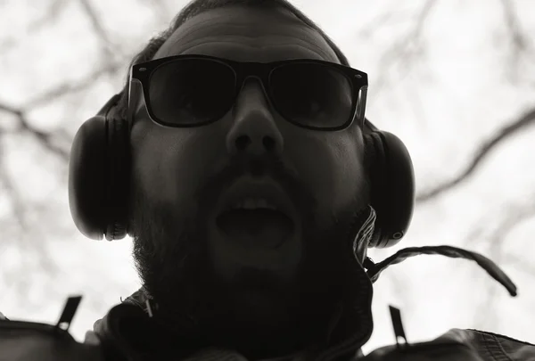 Monochrome beard man listen music in park — стоковое фото