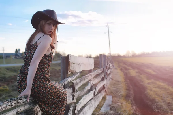 Mädchen mit Cowboyhut am Zaun — Stockfoto